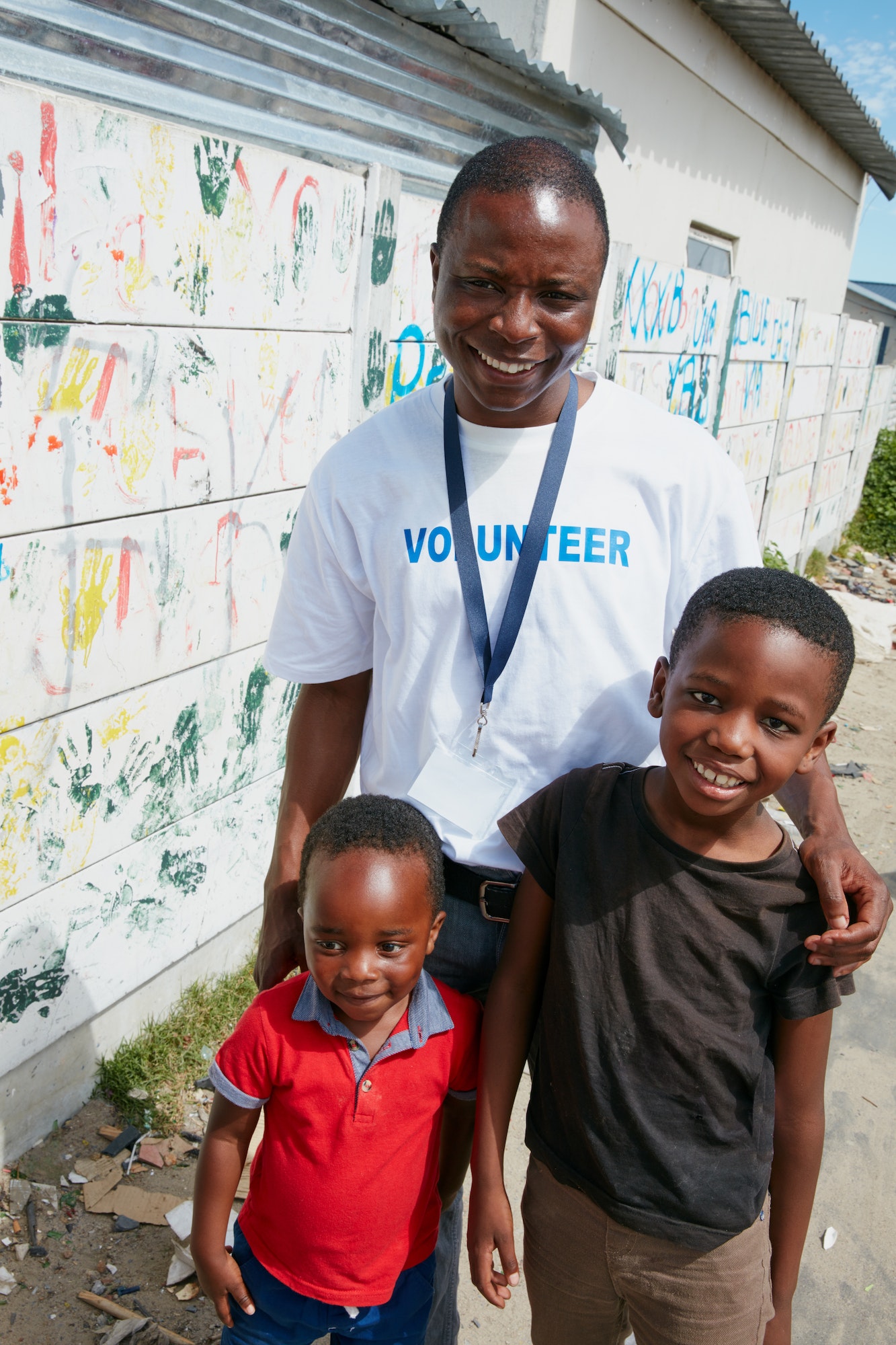 Cropped portrait of a volunteer worker and two young boys at a community outreach event
